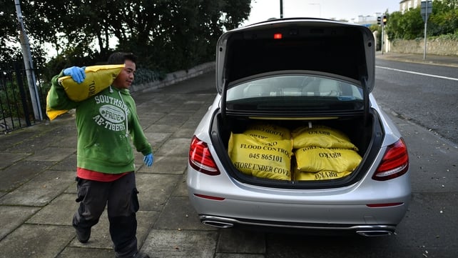 A man at Dublin Bay loads the boot of a car with sandbags to protect homes