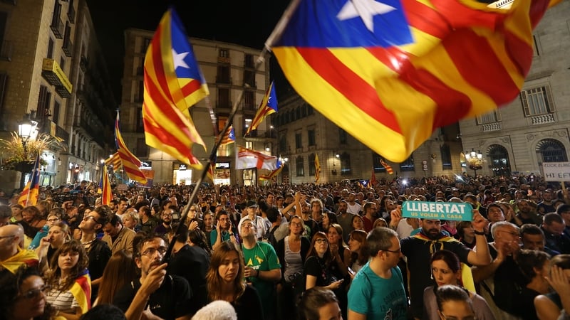 People wave Catalan independence flags while listening to the statement from Carles Puigdemont