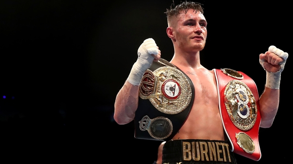 Ryan Burnett celebrates with his IBF and WBA belts