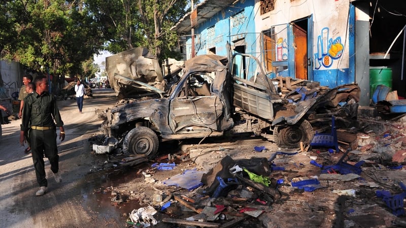 Residents walk at the scene in Mogadishu