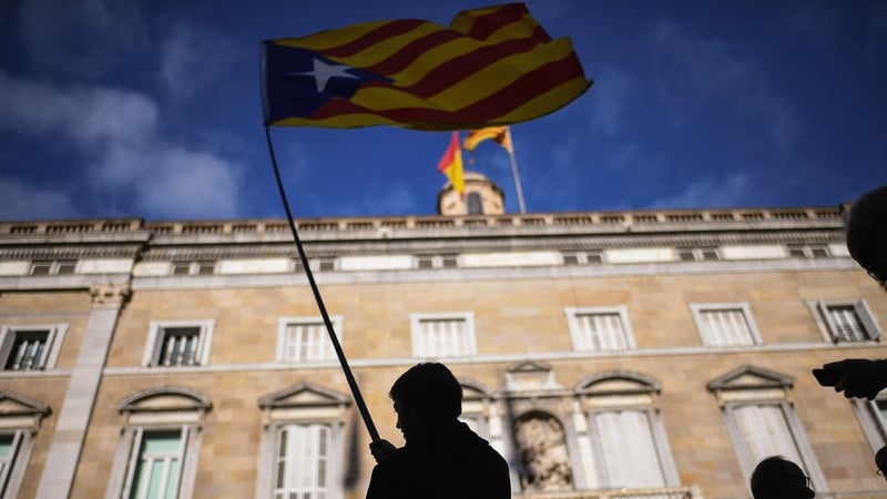 A man waves an independence flag outside the Palau Catalan Regional Government Building