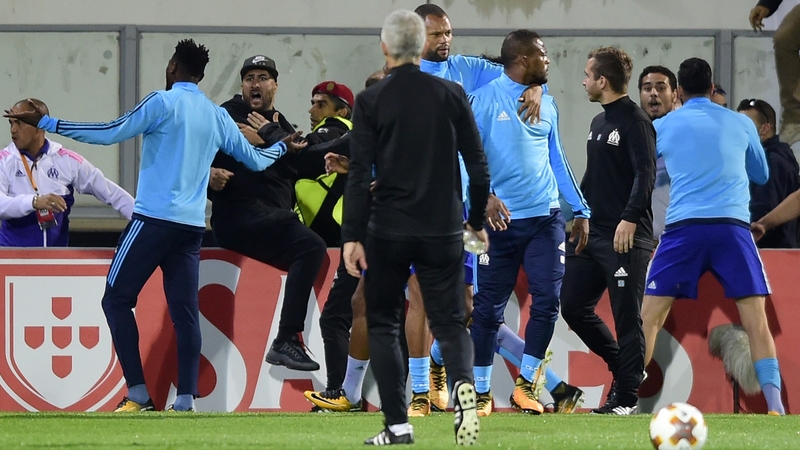 Evra is led away by team-mates after clashing with a fan