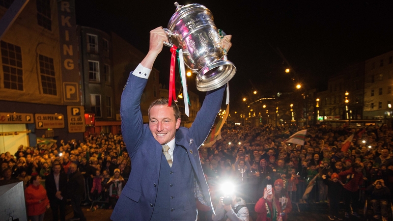 Achille Campion lifts the FAI Cup trophy in front of the waiting Cork City fans