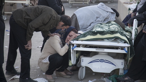 People mourn over the body of a victim in Sarpol-e Zahab in western Iran