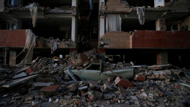 A flattened vehicle underneath building rubble is seen following the earthquake