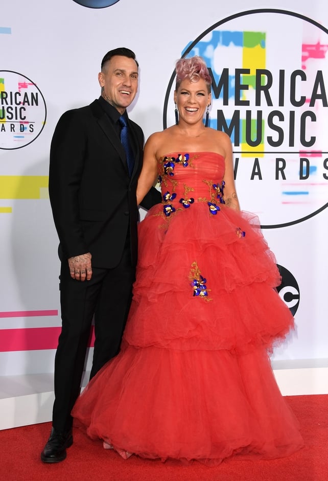 Carey Hart and Pink were all smiles on the red carpet. Carey wore a black suit with blue tie while Pink wore a Monique Lhuillier gown.