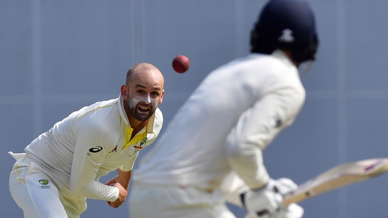 Australia's Nathan Lyon (L) bowls to England's batsman James Vince (R)