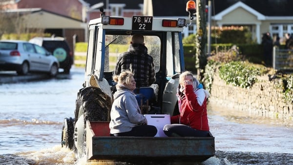 A tractor helps women through the floods in Mountmellick, Co Laois