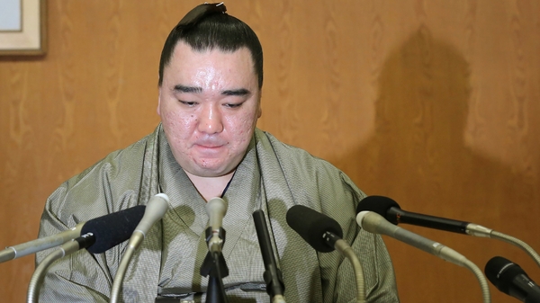 Mongolian-born yokozuna, or grand champion, Harumafuji bites his lips at a press conference to announce his retirement