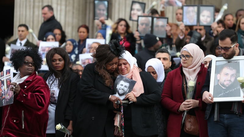 Photos of those who died are held by relatives
