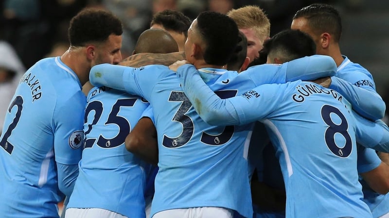 Manchester City players mob Raheem Sterling after his decisive goal