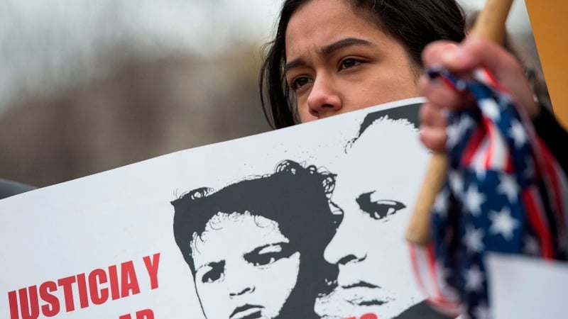 A young girl looks on during a protest near the White House over plans to end TPS for Salvadorans