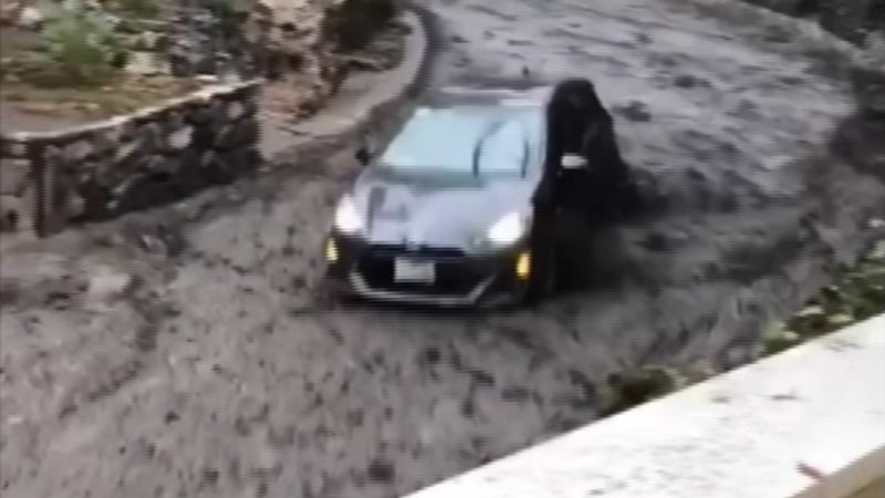 The car had its lights and wipers on as it was pushed through the street