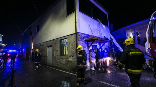 Firefighters stand outside the community centre in Vila Nova da Rainha in Tondela