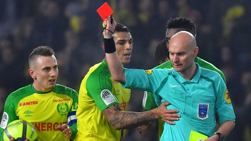 Nantes' Brazilian defender Diego Carlos (C) receives a red card, much to his dismay