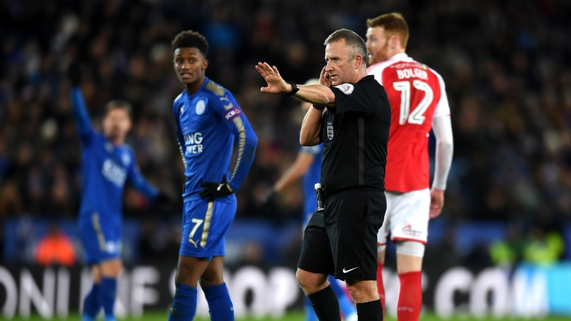 Referee Jon Moss in communication with the video assistant referee in the Leicester-Fleetwood clash