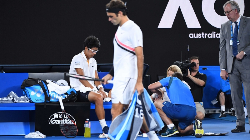 Roger Federer of Switzerland walks past Hyeon Chung of South Korea
