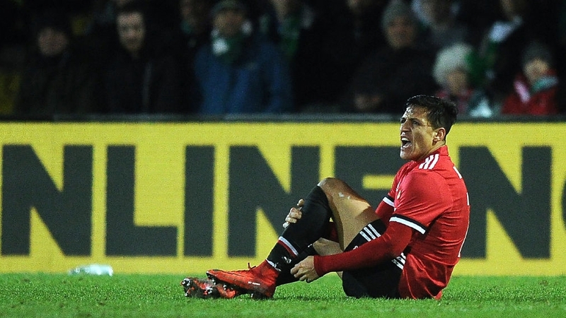 Sanchez holds his ankle after a tackle