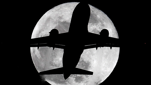 A plane passes in front of the moon in London. The supermoon was visible across the world.