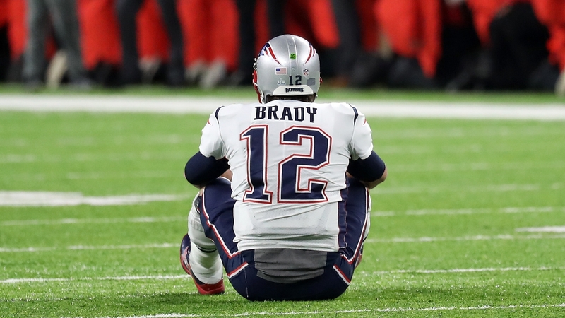 Tom Brady sits dejected following defeat to the Eagles
