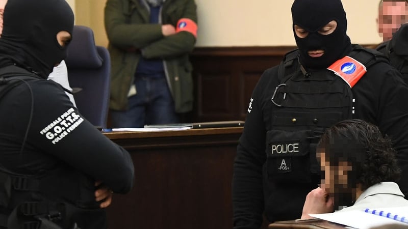 Salah Abdeslam sits as he is surrounded by Belgian special police officers in the courtroom in Brussels