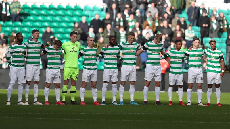 Celtic players observe a minute's silence ahead of the game