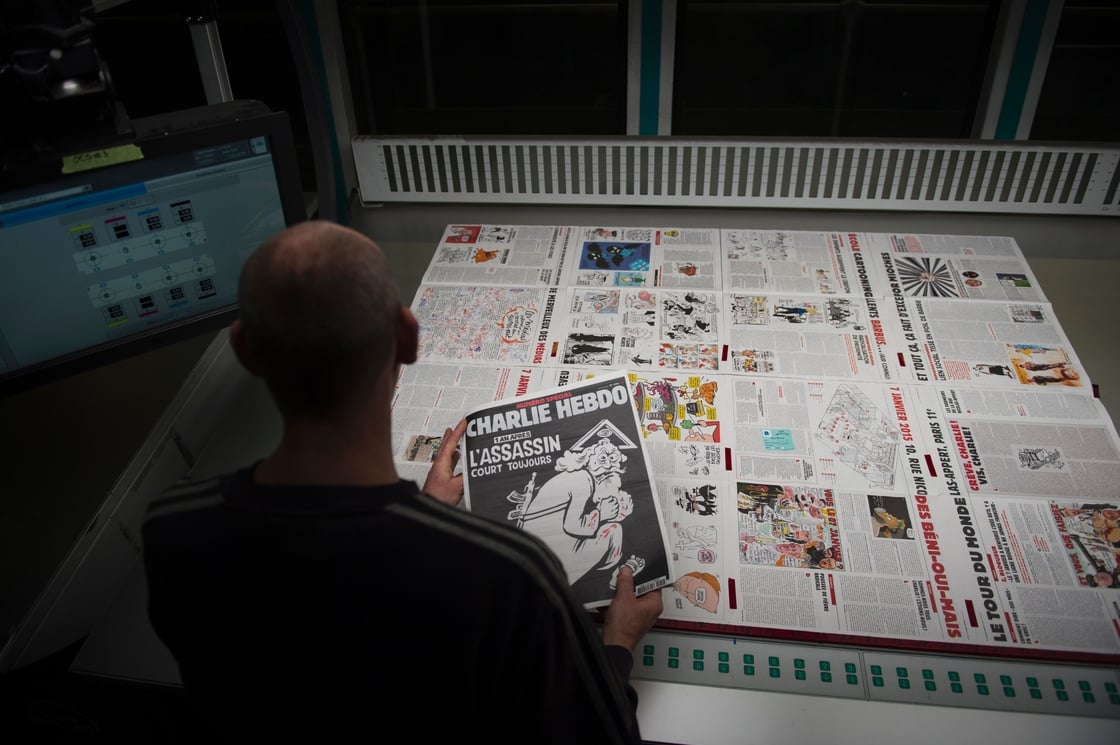 A printer with a copy of Charlie Hebdo published to mark the first anniversary of the terror attack