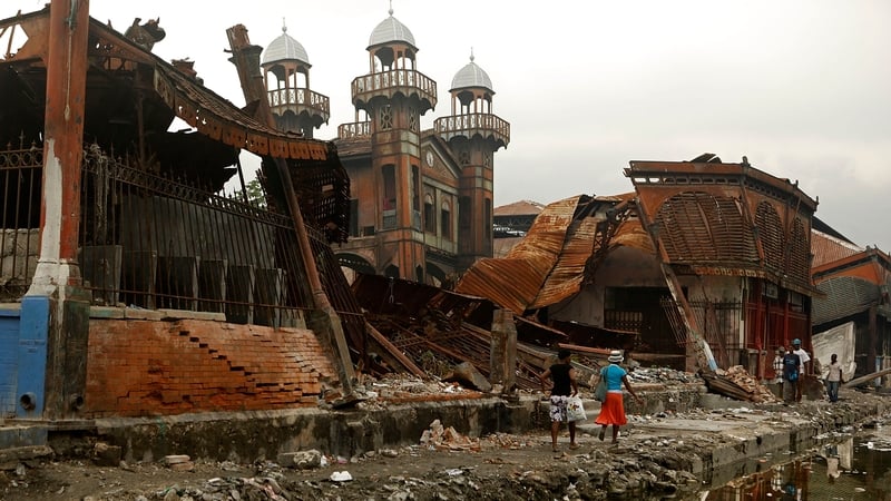 People walk past the earthquake -destroyed Iron Market in Port-au-Prince in 2010