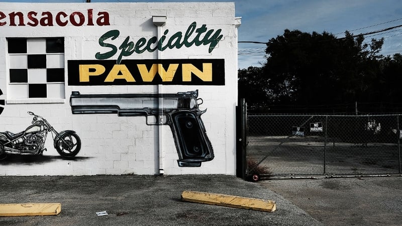 A pawn shop wall in Pensacola is painted with guns and other items