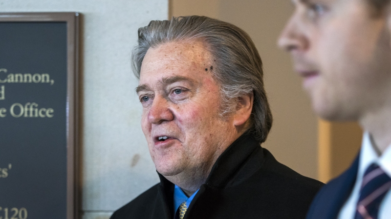 Former White House strategist Steve Bannon (L) arrives to testify before the House Intelligence Committee