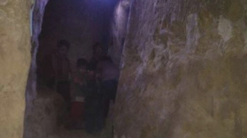 A family huddles in a bomb shelter in Eastern Ghouta (Pic: Women Now)