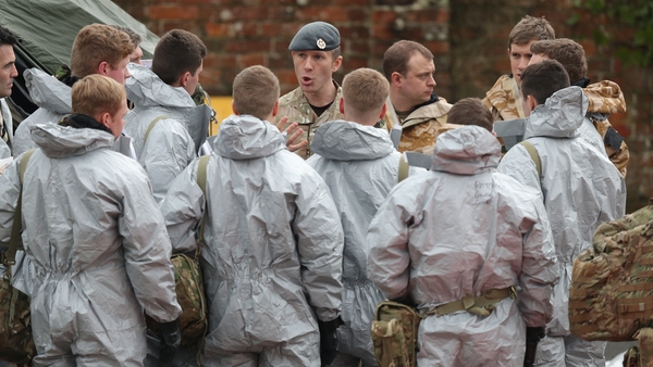 Military personnel in protective clothing prepare to remove vehicles from a car park in Salisbury, England, today