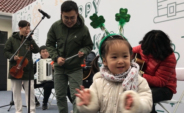 A little girl enjoys the traditional music at the Saint Patrick's Open Day at the Embassy of Ireland in Beijing, China