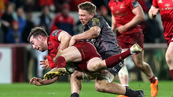 Munster's JJ Hanrahan is tackled by James Davies of the Scarlets