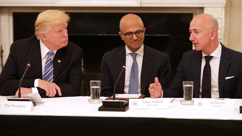 Some analysts believe Donald Trump's dislike of Amazon might be personal against Jeff Bezos (r) rather than business