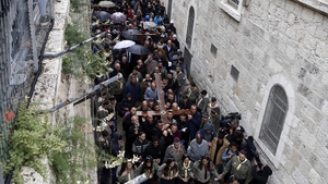 Christian pilgrims carry a large wooden cross along the Via Dolorosa (Way of Suffering) in Jerusalem's Old City