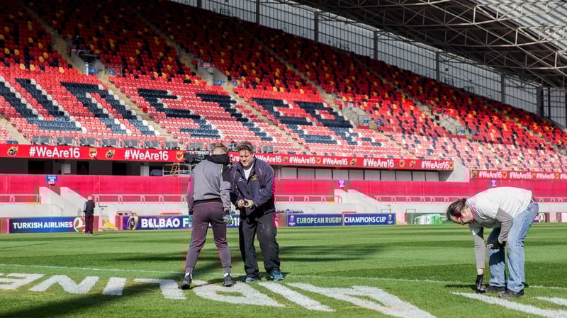 Ground staff work on the pitch ahead of the game