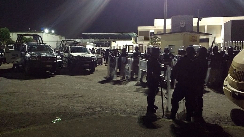 Federal Police agents stand guard outside the La Toma jail following the riot