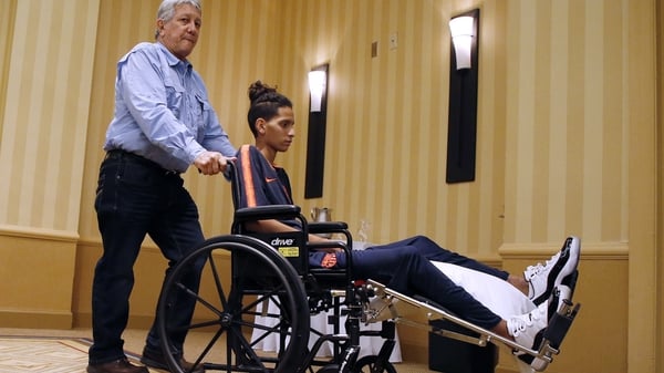 Anthony Borges is wheeled out of a press conference by his grandfather
