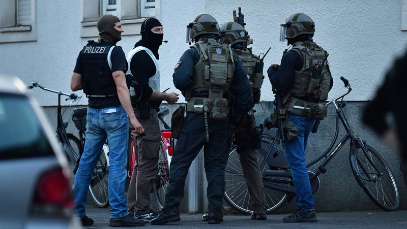 Members of an armed police unit search the apartment of the suspect in Muenster, Germany