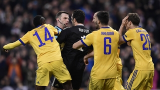 Juventus players surround referee Michael Oliver after the late, late penalty that sealed their fate