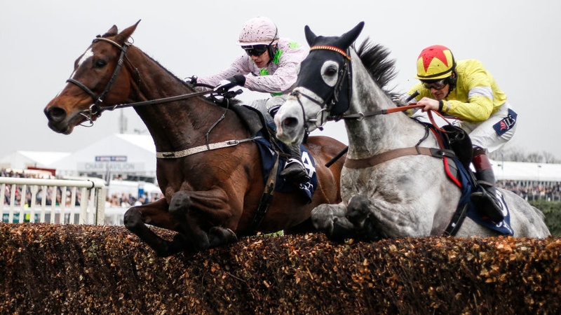 Sam Twiston-Davies riding Politologue (R) clears the last to win The JLT Melling Chase from Min (L) at Aintree