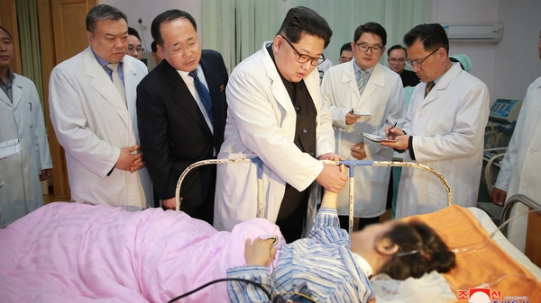 North Korean President Kim Jong-un (C), visiting a victim of the bus crash