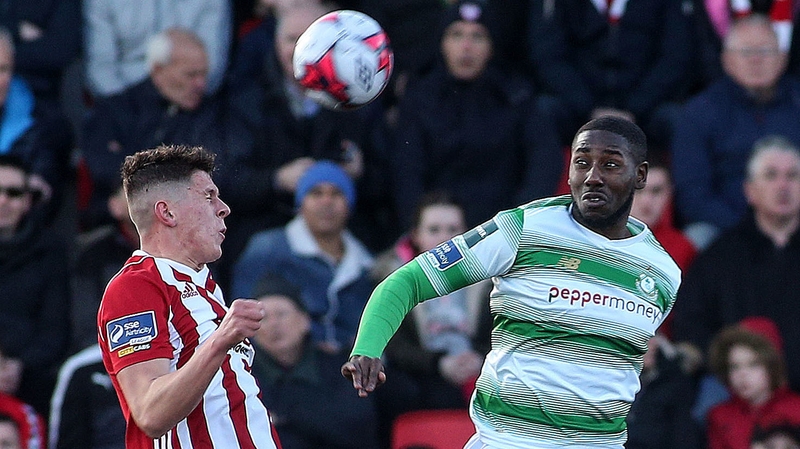 Eoin Toal and Danny Carr (R) battle for possession