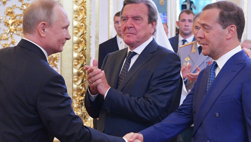 Russian President Vladimir Putin shakes hands with Russian Prime Minister Dmitry Medvedev