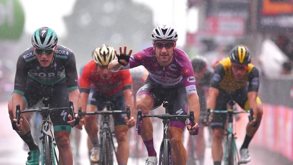 Elia Viviani strikes a pose as he crosses the finish line with Sam Bennett (l) in second place