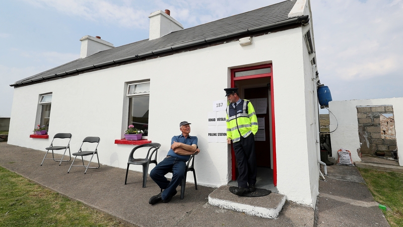A resident of Gola Island speaks to a garda as he waits to cast his vote in his home which has been turned into a polling station for the day