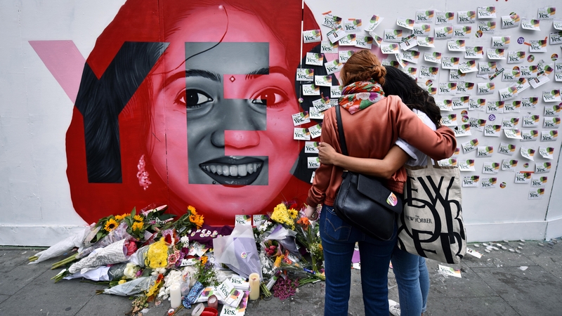 Two women stand at the Savita Halappanavar mural in Dublin today