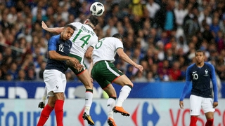 Corentin Tolisso rises with Alan Browne and Callum O'Dowda