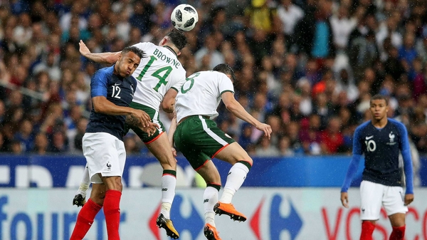 Corentin Tolisso rises with Alan Browne and Callum O'Dowda